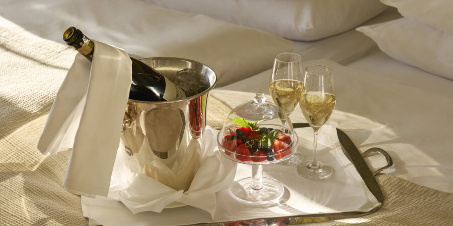 Champagne och färska bär serverade på rumsservicebricka i ett hotellrum på hotell diplomat